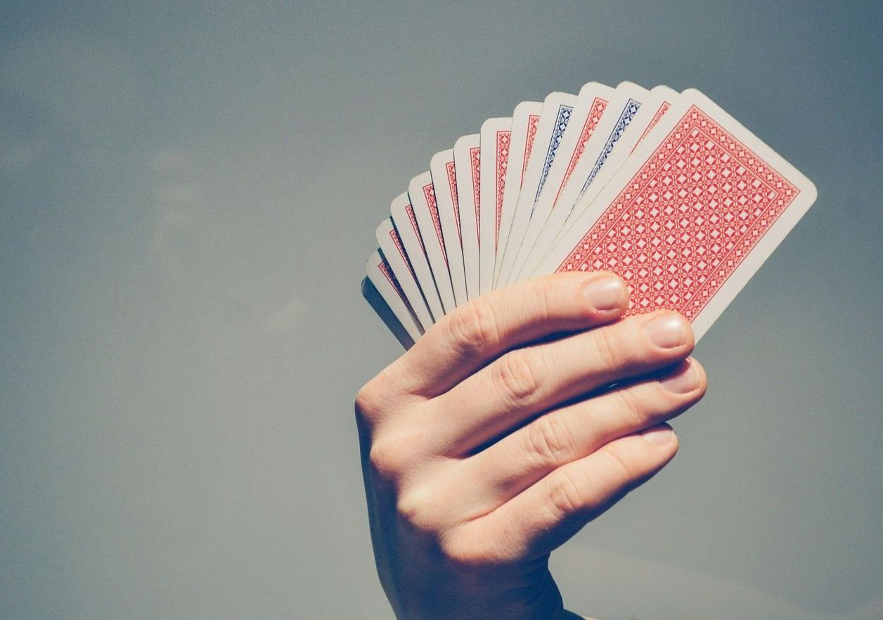 Hand of playing cards held to the sky